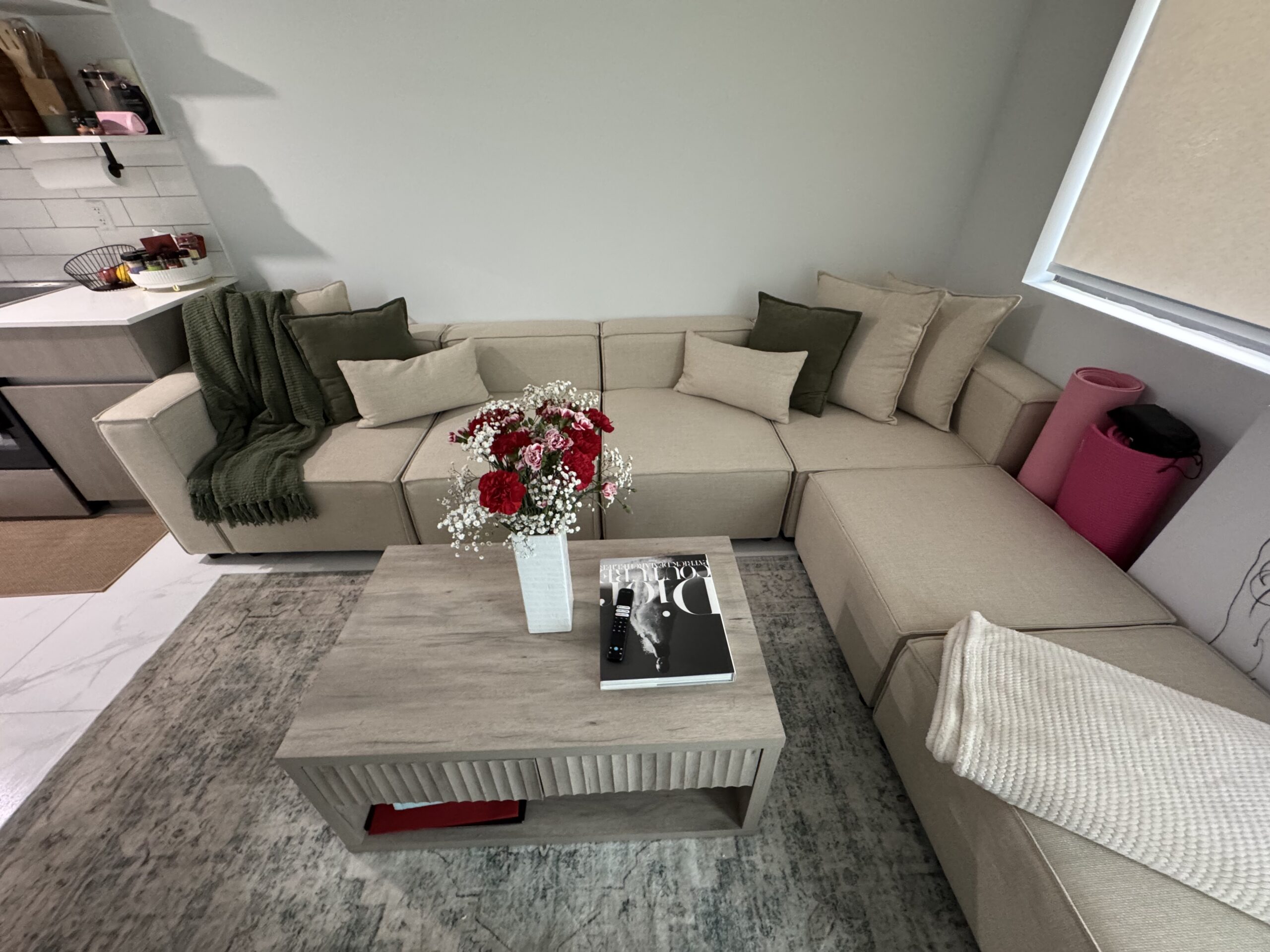 After photo of a professionally cleaned living room in Dallas TX by Monarch Texas Cleaning. Floors vacuumed, sectional sofa tidied, and all surfaces cleaned as part of a recurring basic house cleaning service.